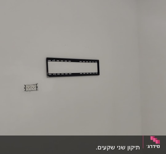 קיר עם שקע חשמל ומתקן תלייה